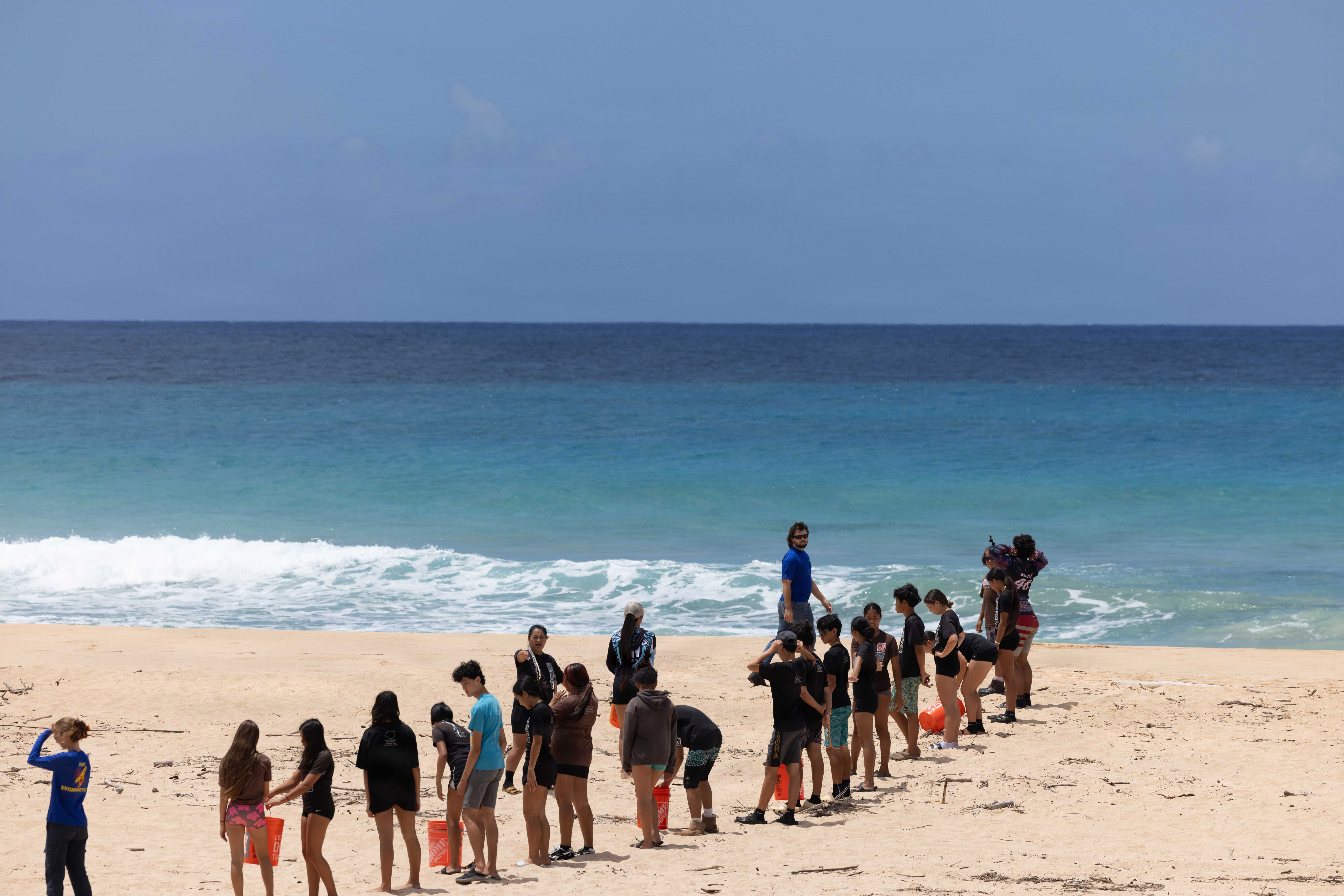 Students prepare to place their pohaku on the Lua Kupapa‘u O Nohili crypt.